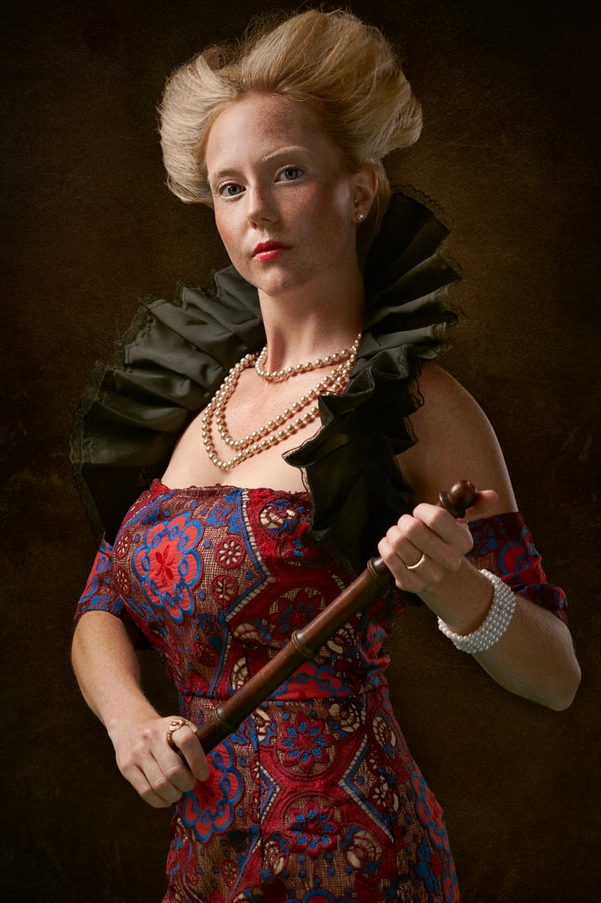 photo of woman looking while holding a wooden baton